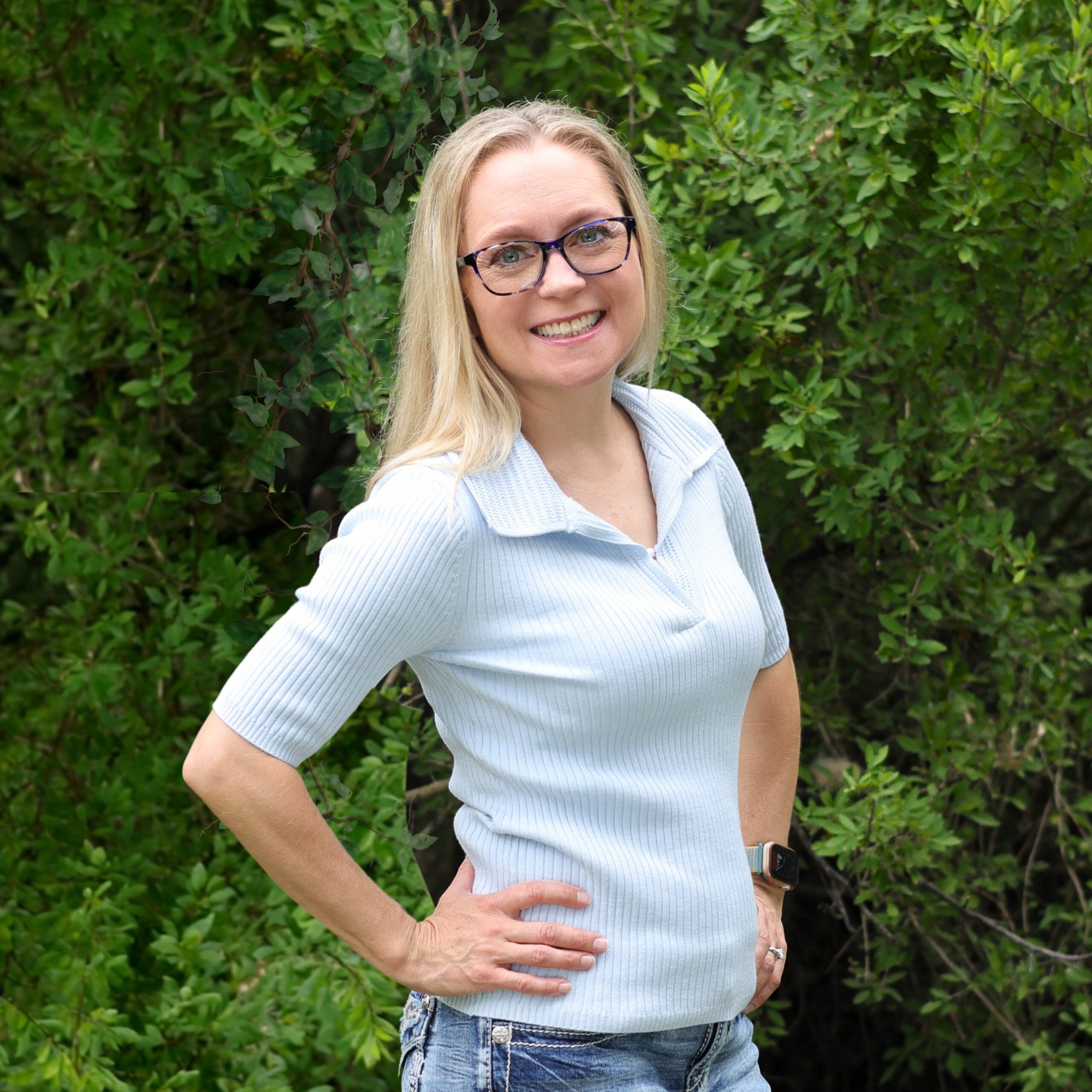 A blonde woman wearing a blue collared shirt.